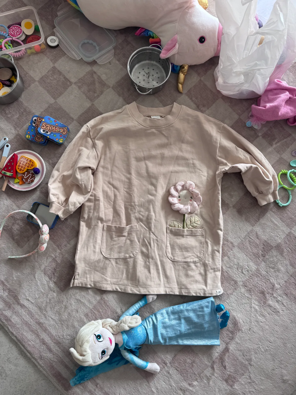 Item crumpled on a messy bed with toys and laundry in frame
