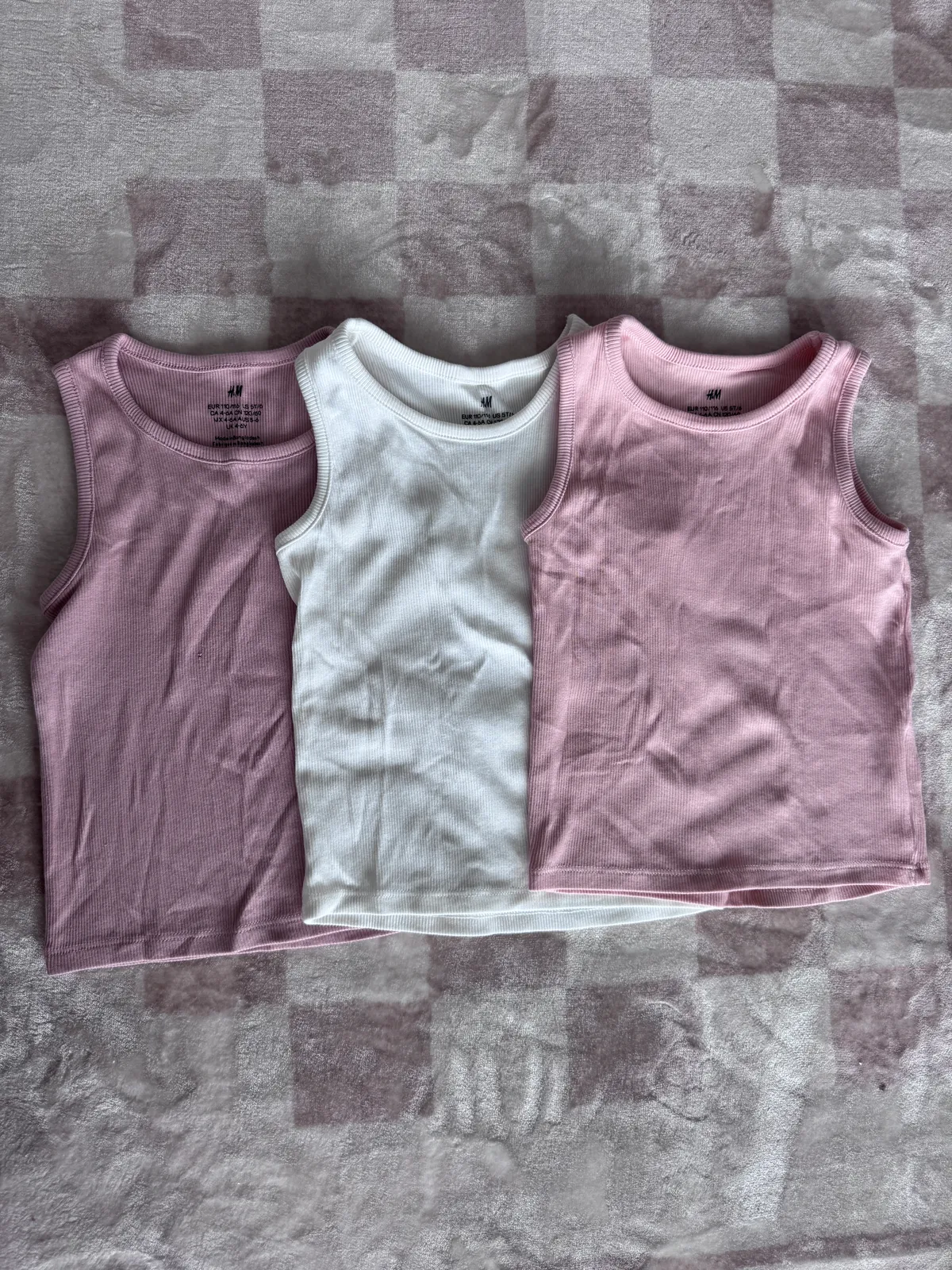 Three pyjama sets laid out flat, all visible and evenly spaced